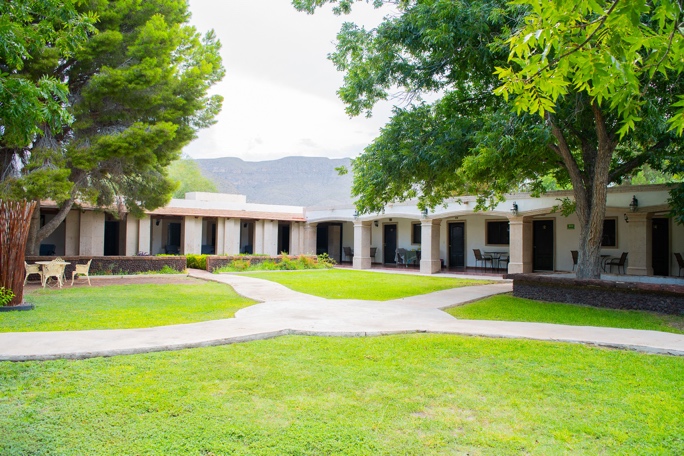 A building with columns and a lawn

AI-generated content may be incorrect.