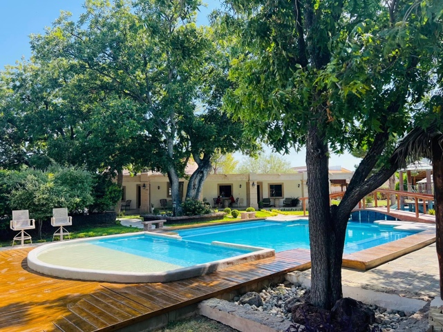 A swimming pool with trees around it

AI-generated content may be incorrect.